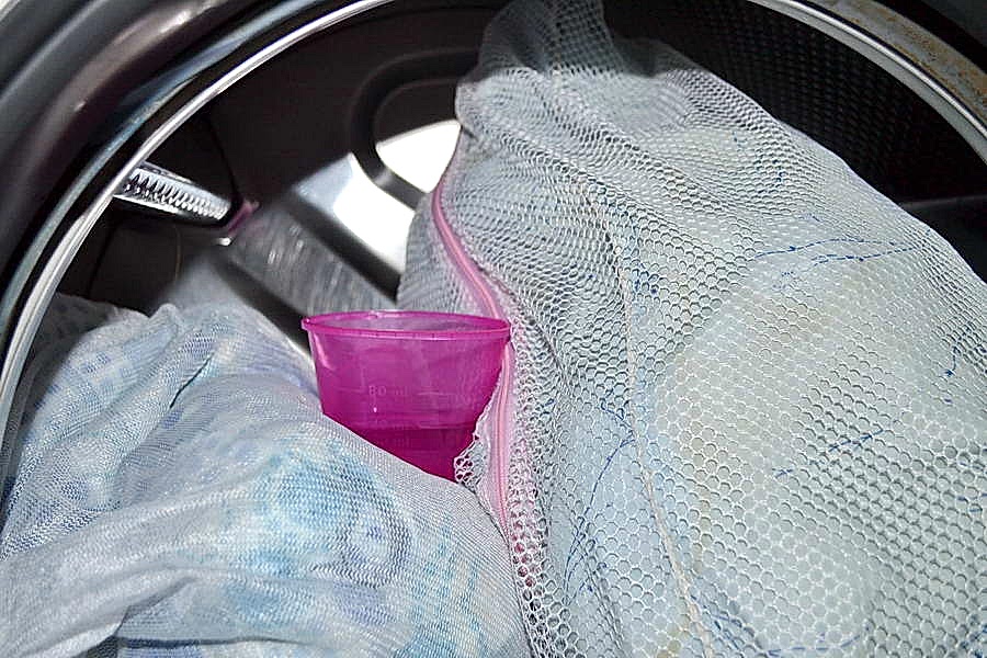 Загрузите подушки и моющие средства в барабан машины, а кондиционер в специальное отделение и запустите цикл.